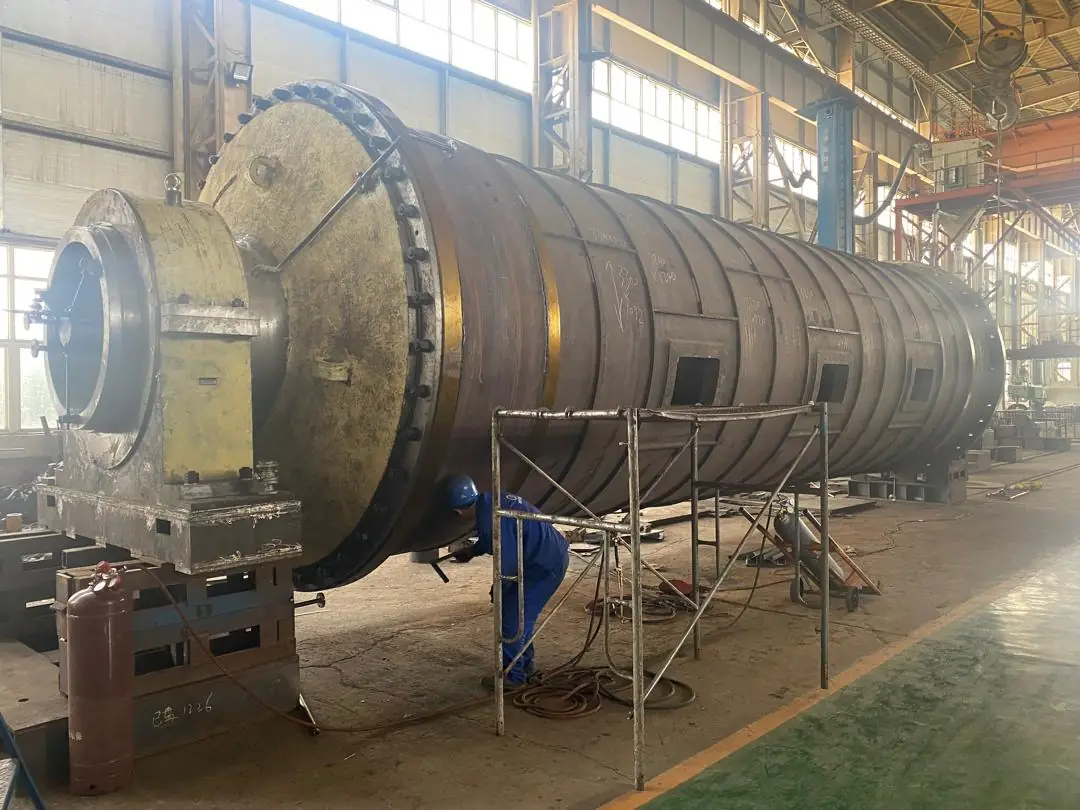 Large cylindrical steel shell standing in a workshop