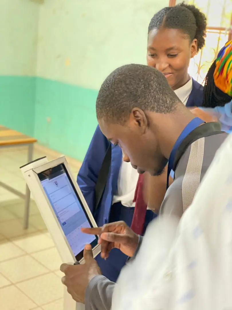 Two students using a tablet on a stand